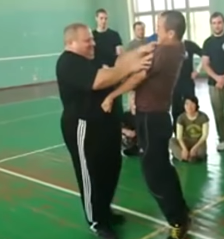 Portly Systema instructor pokes at even more pressure points on training partner.